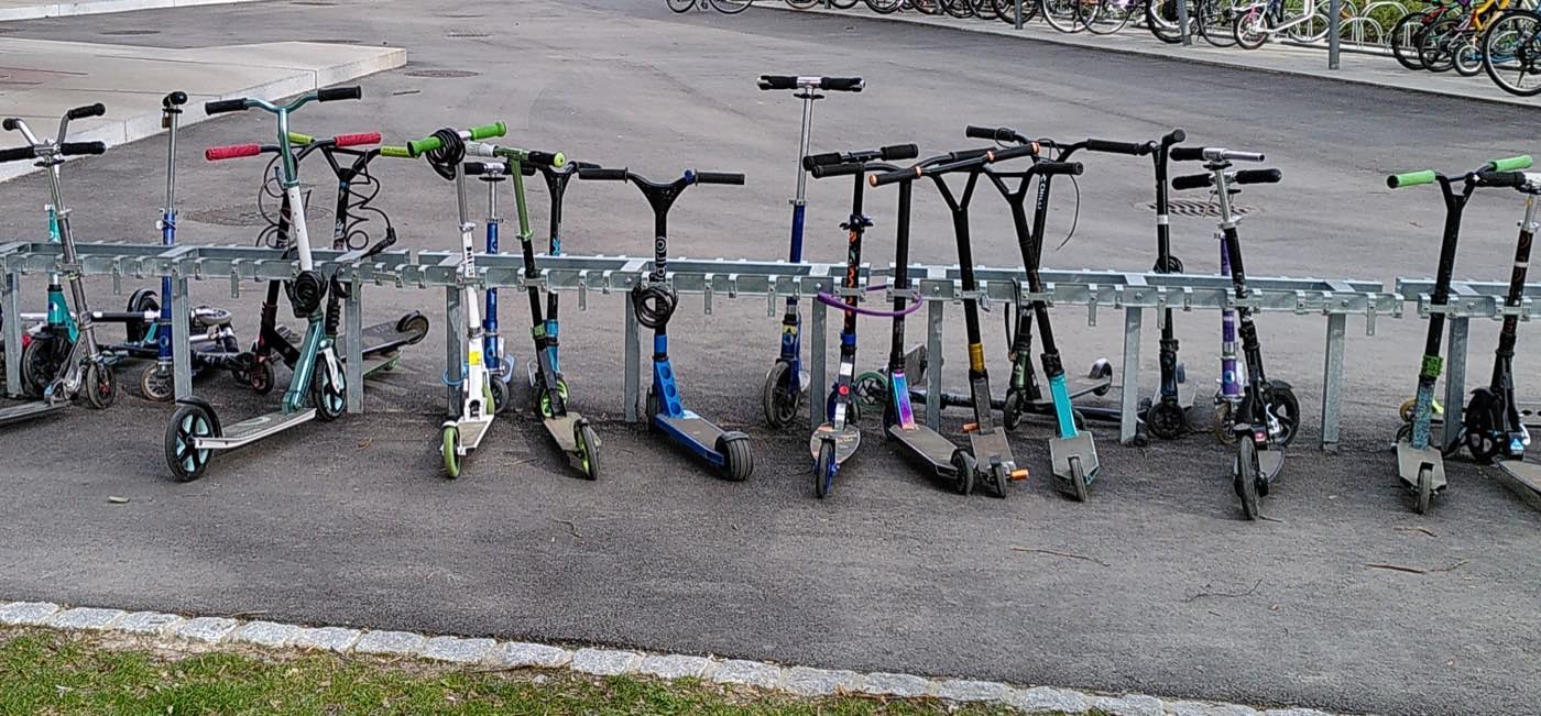 Kick scooters lined up in a parking area